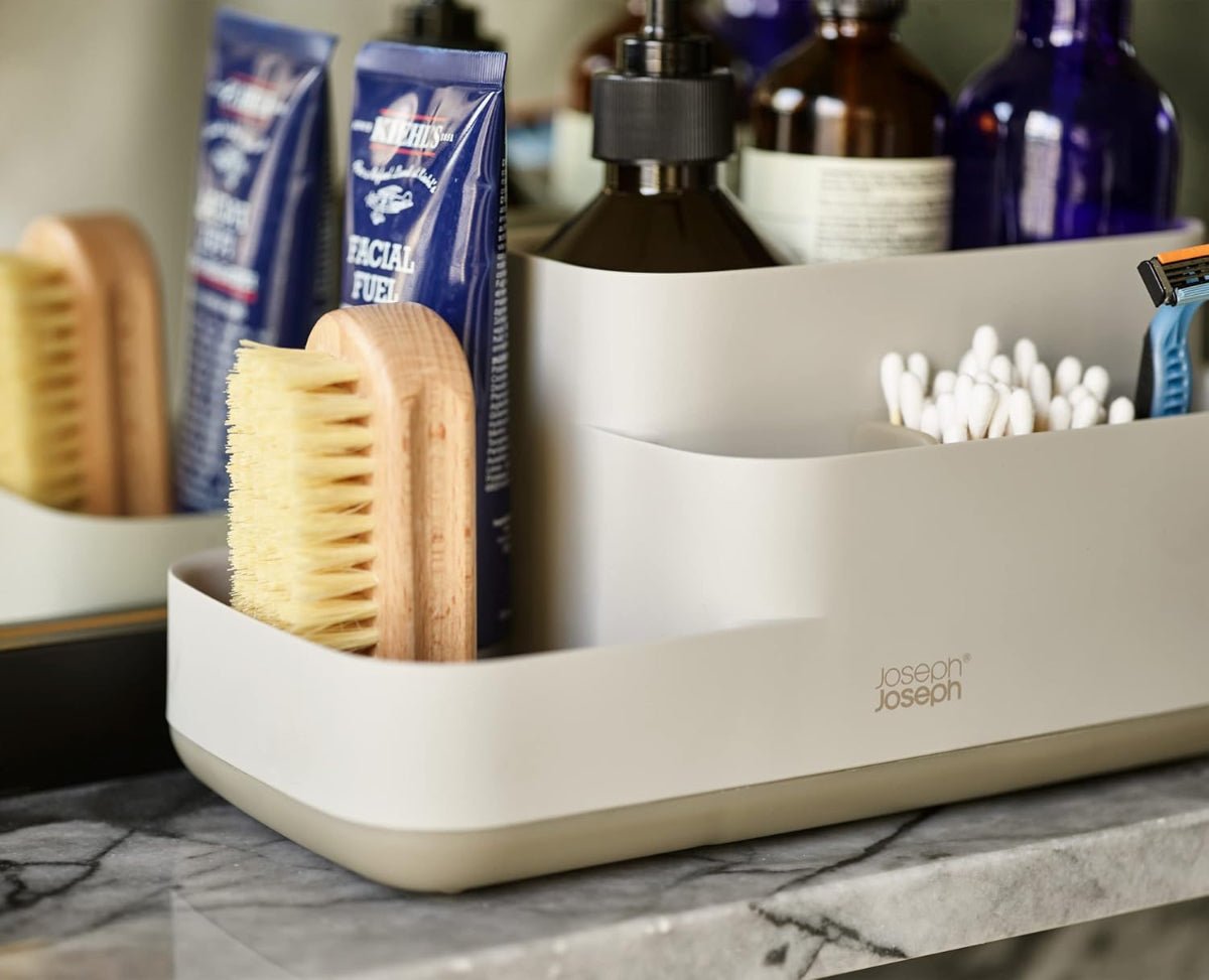 Organized bathroom counter with Joseph Joseph EasyStore Caddy filled with toiletries like toothbrushes, toothpaste, and skincare products