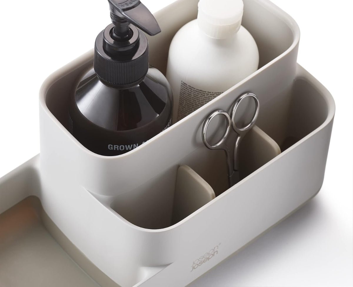 Organized bathroom counter with Joseph Joseph EasyStore Caddy filled with toiletries like toothbrushes, toothpaste, and skincare products