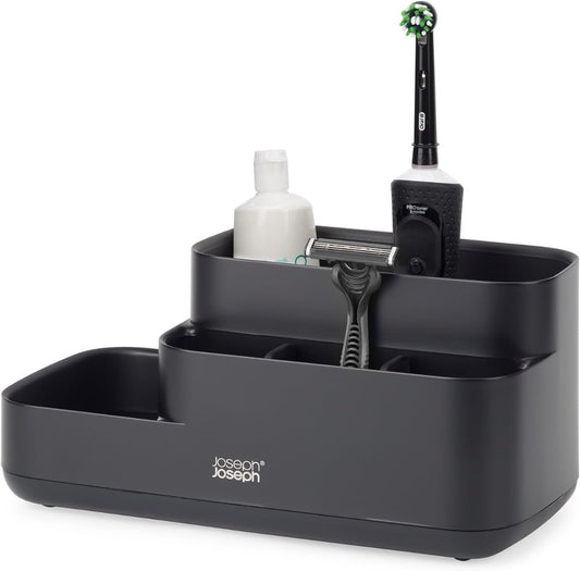 Organized bathroom counter with Joseph Joseph EasyStore Caddy filled with toiletries like toothbrushes, toothpaste, and skincare products
